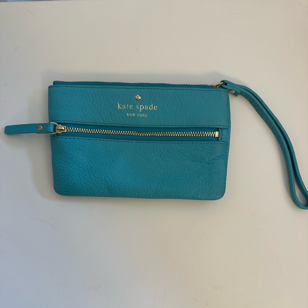 Kate Spade blue wristlet with striped interior and front zipper pouch.